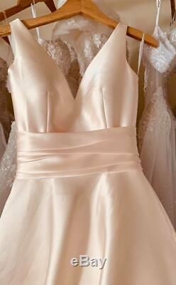 Minimalistic satin wedding dress or ball gown in blush coral with big bow detail