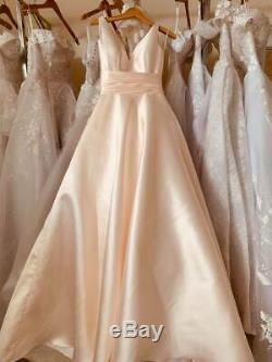 Minimalistic satin wedding dress or ball gown in blush coral with big bow detail